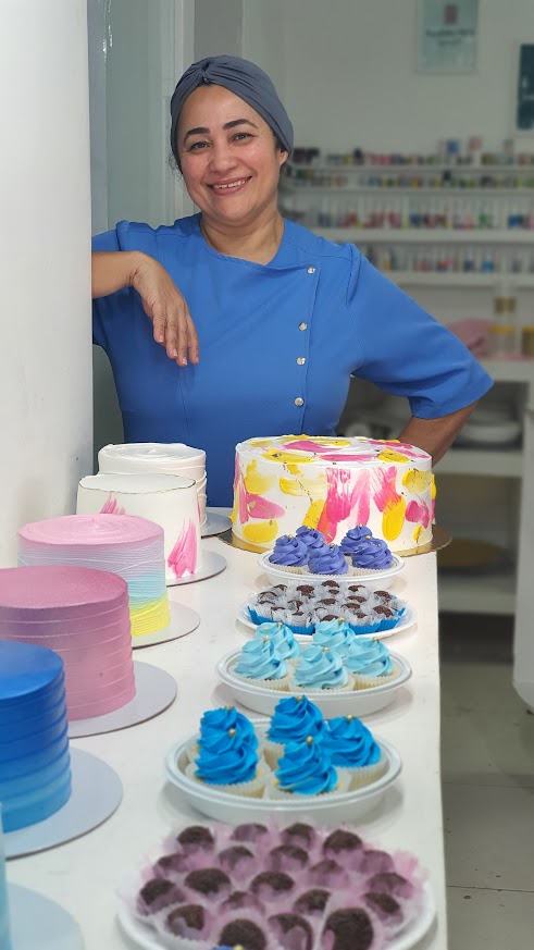 Confeiteira do Nosso Sabor com bolos e doces